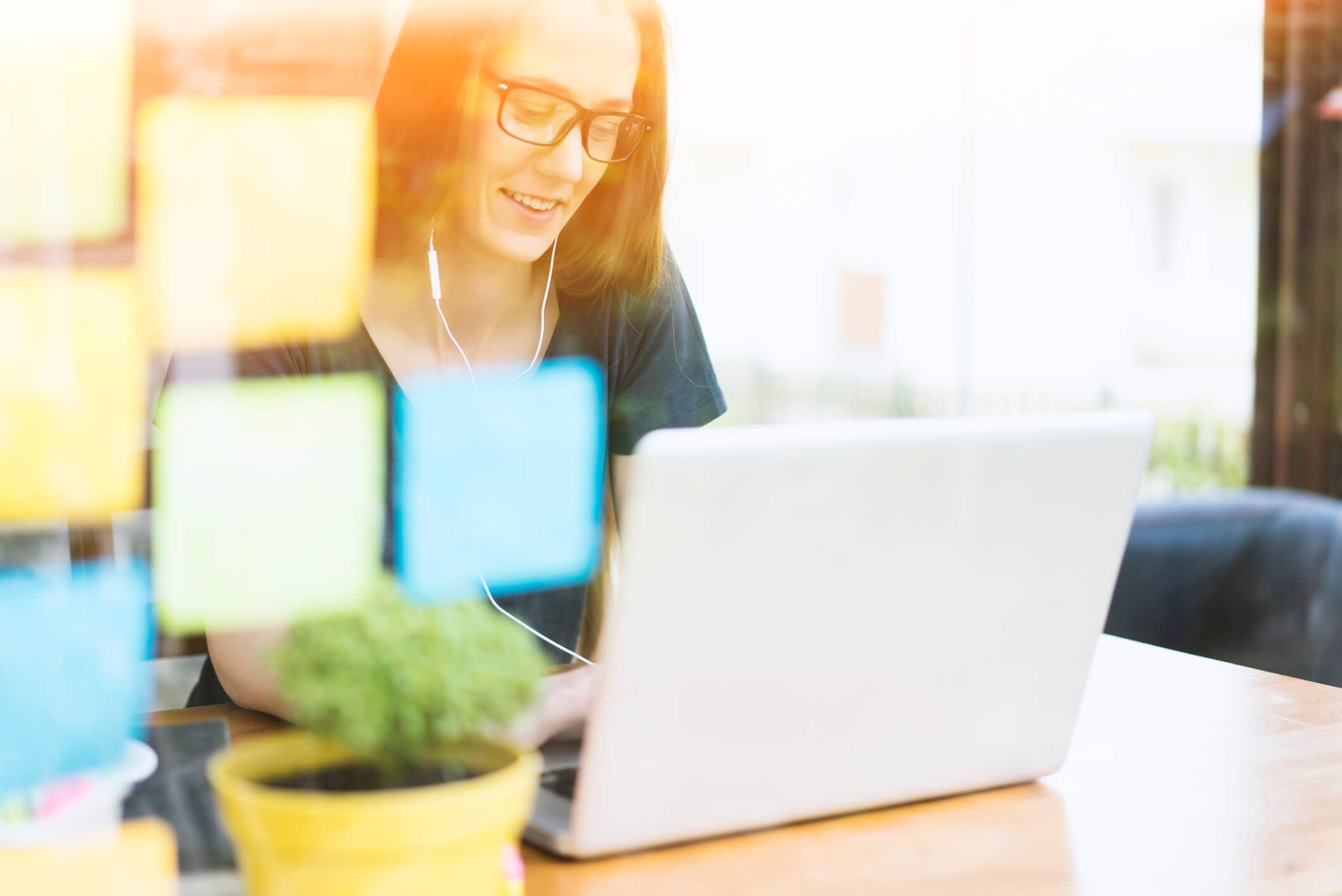 marketing de conteúdo: jovem mulher usando seu computador com post its